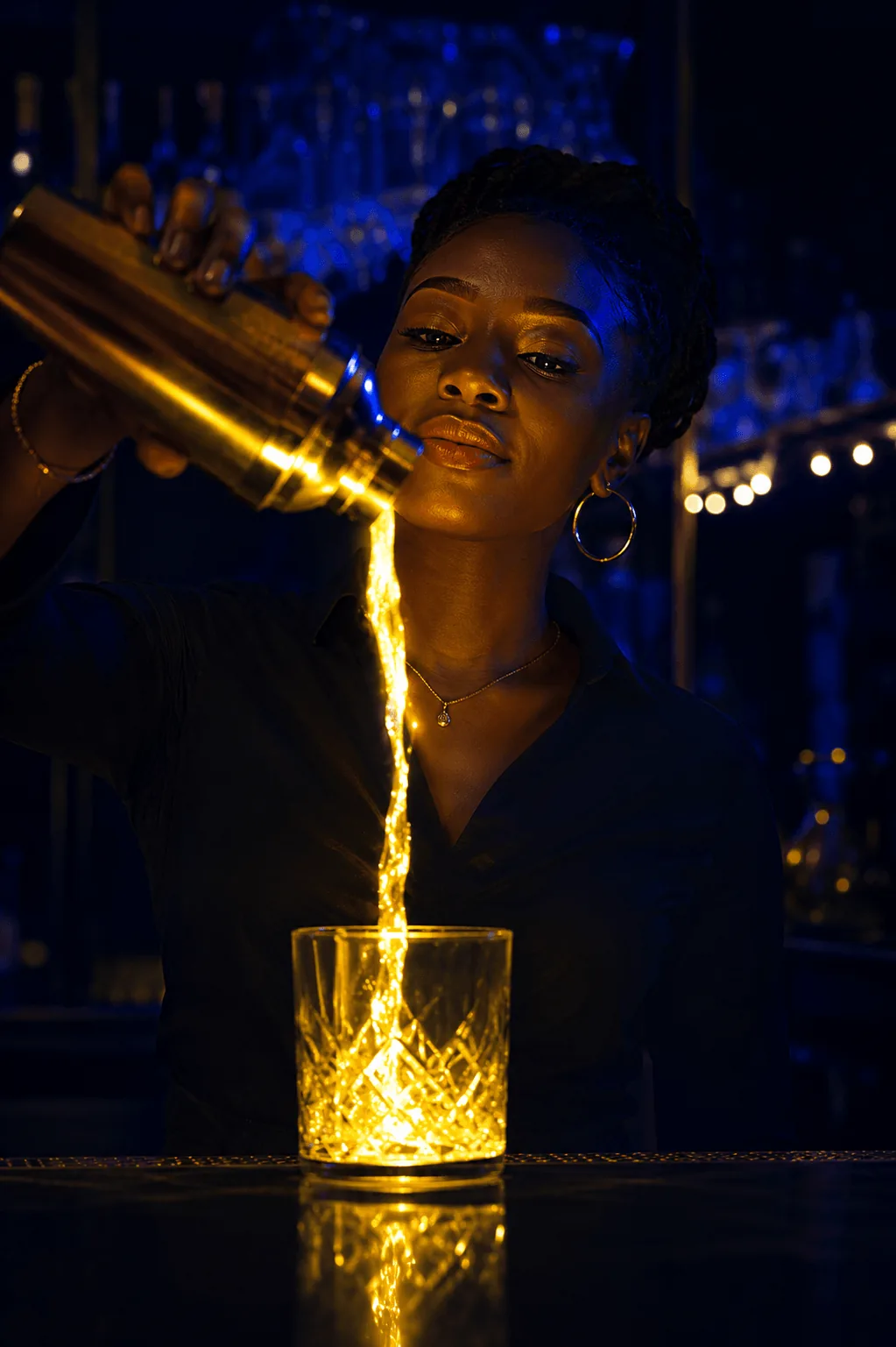 A Sun City bartender pouring a glowing golden cocktail